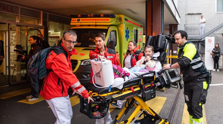 Rettungssanitäter und medizinische Fachpersonen transportieren ein junges Mädchen auf einer Transportliege