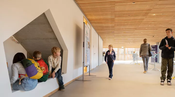 Erwachsene und Kinder entdecken eine Spielecke unter einer Treppe im Akutspital des Kinderspitals Zürich