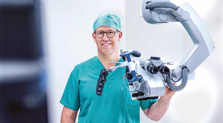 Prof. Dr. med. Niklaus Krayenbühl mit OP-Roboter