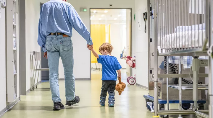 Ein Grossvater und sein Enkel laufen durch das Kinderspital Zürich