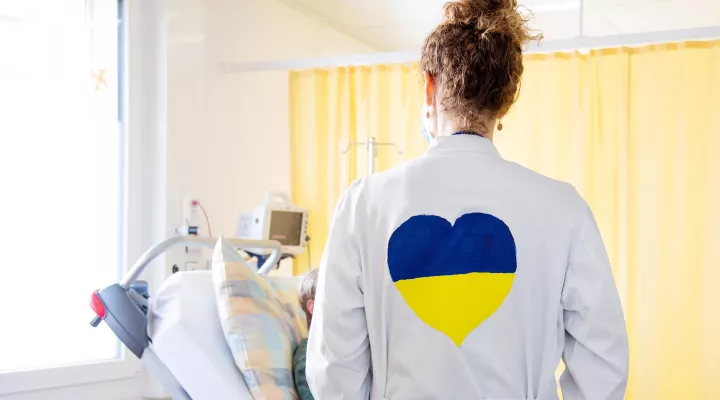 Ärztin mit Ukraine-Farben am Patientenbett