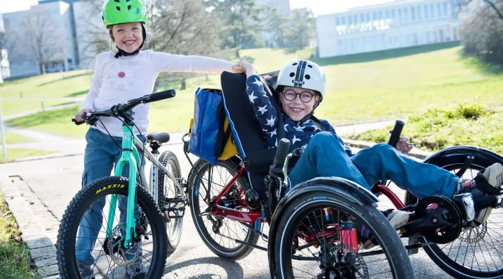 Patient im Rollfahrrad mit Schwester auf Velo