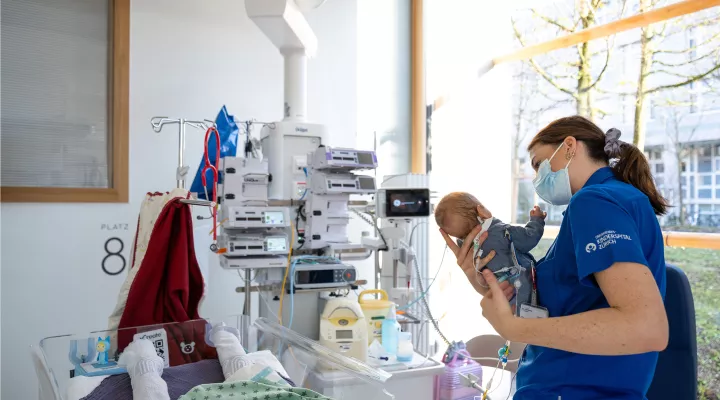 Pflegefachfrau der Neonatologie hält einen Säugling in den Händen im Akutspital Lengg