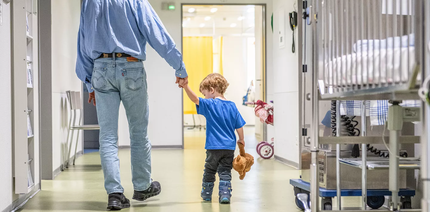 Ein Grossvater und sein Enkel laufen durch das Kinderspital Zürich