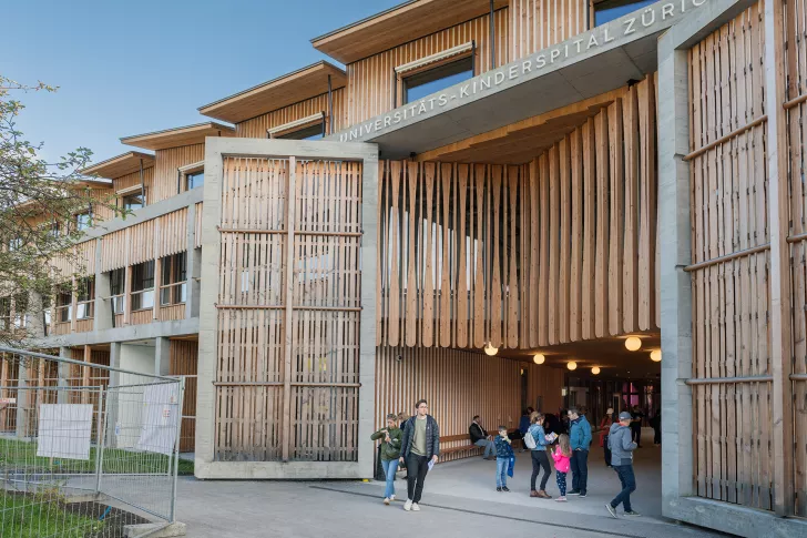 Vor dem Haupteingang des Universitäts-Kinderspitals Zürich stehen Besucherinnen und Besucher